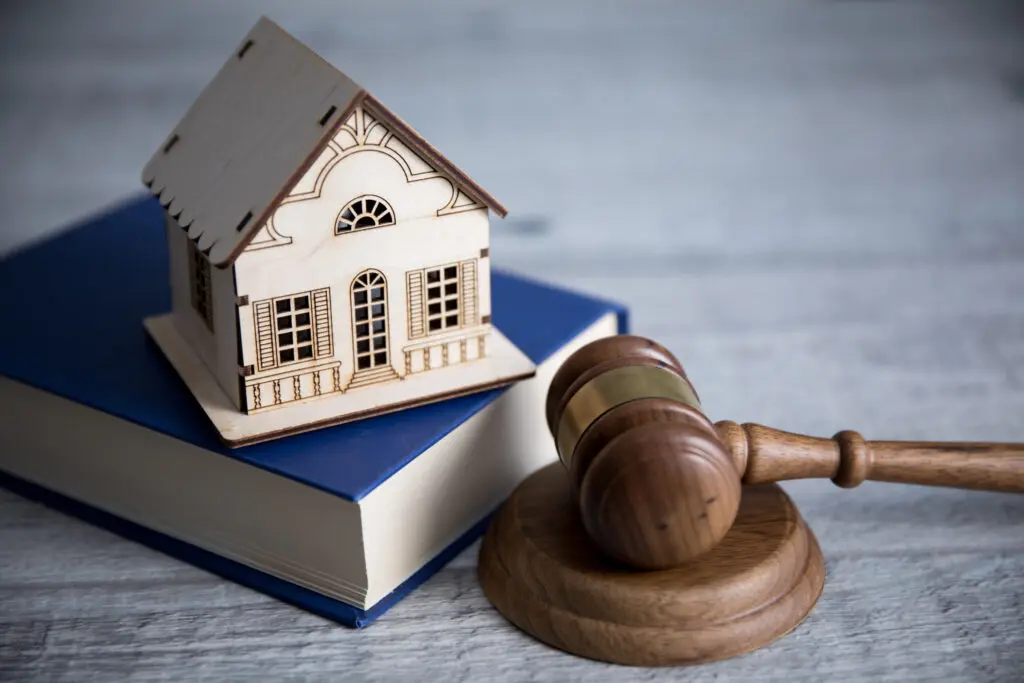 A wooden gavel next to a small house.