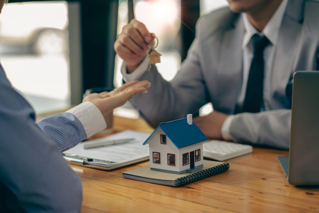 A man handing over the keys to another person.