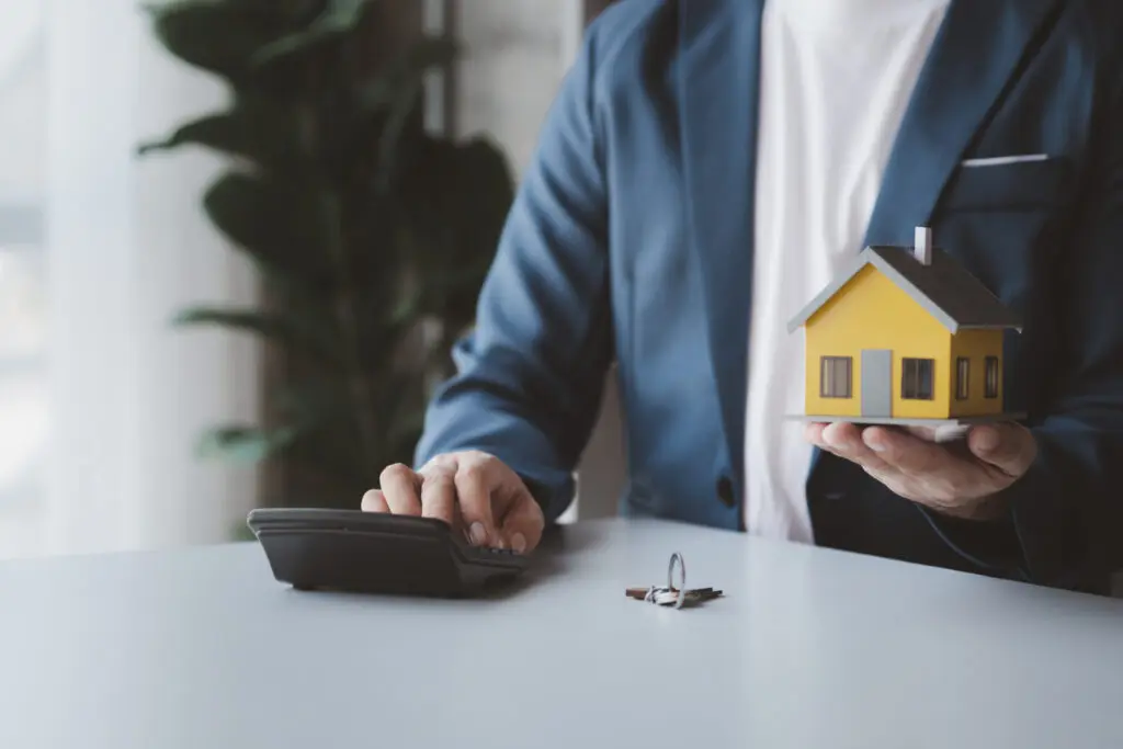 A person holding a house and a calculator